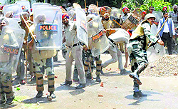 Policemen protect themselves from stones