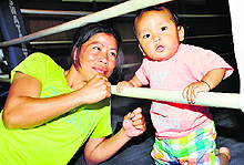 MC Mary Kom, who did not box on Wednesday, poses with her son during a break from practice in Patiala