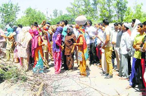 Women block the Gohana-Jind road in Butana village on Thursday.