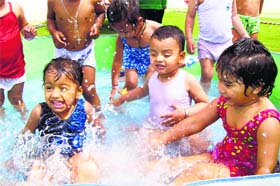 Tiny tots enjoy during a splash pool party at Kids Castle Pre-School on Wednesday.