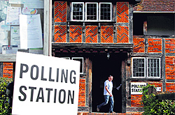 A man leaves the polling station after casting his vote in London on Friday