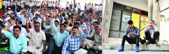Ministerial employees protest at Parade Ground in Dehradun; men sit outside the regional transport office due to employees strike in Dehradun on Friday.