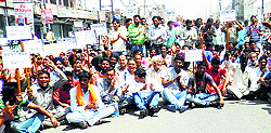 MC employees stage a dharna on a railway overbridge in Jagraon on Friday