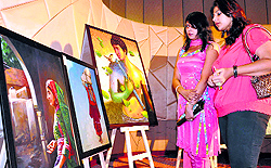Visitors admire paintings during an exhibition at Radisson Blu Hotel in Ludhiana on Friday