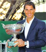 Defending French Open champion Rafael Nadal poses with the trophy on a tennis court built in front of the Eiffel tower in Paris late on Thursday.