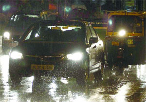 Vehicles move very slowly during the sudden rain in New Delhi on Saturday.