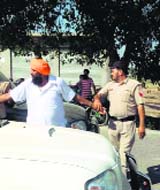 Policemen detain Akali leader Baba Avtar Singh at Daulewala village in Moga on Saturday.