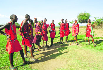 Villagers from the Masai tribe get ready to perform a dance to welcome visitors to the reserve
