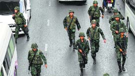 Soldiers walk down a street as they take their positions during a protest against military rule, in Bangkok on Saturday.