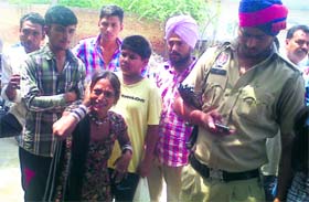 A policeman makes a call while the residents slap a woman beggar who was pregnant at 60-Feet Road in Bathinda on Sunday.