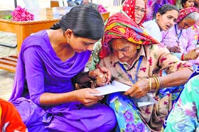 Literacy drive: A volunteer of NGO Each One Teach One helps a woman write in Shahpur village on Sunday