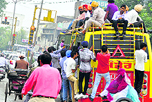 An overloaded bus moves on a city road