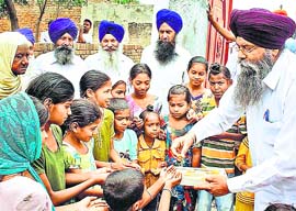Jubilant residents of Umra Jatti village in Amritsar district distribute sweets after the announcement of Pakistan Premier Nawaz Sharifs visit to New Delhi for Narendra Modis swearing-in on Monday.