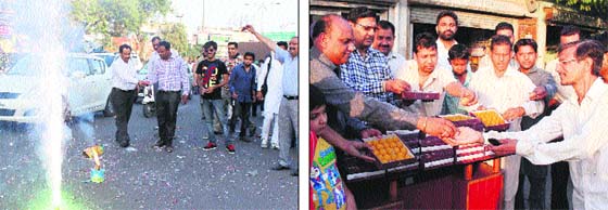 BJP workers burst crackers; (right) distribute laddoos to celebrate the swearing-in Narendra Modi as PM and Harsimrat Kaur Badal as Union minister in Bathinda on Monday