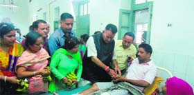 MLA Mussoorie Ganesh Joshi distributes fruits at Doon hospital in Dehradun on Monday.