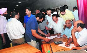 UT excise officials examine bid documents for the allottment of liquor vends at the GMCH auditorium in Sector 32, Chandigarh.
