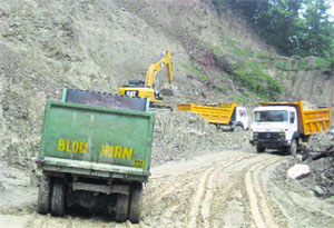 A machine loads a tipper at Hanuman Mandir near the National Highway-21 in Sundernagar on Tuesday.