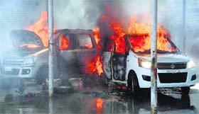 Flames rise from cars during a fire at a workshop in Batamallo in Srinagar on Tuesday.
