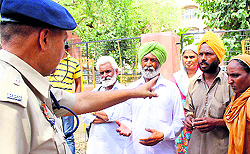 Superintendent of Police (City) Narender Pal talks to the protesters outside the District Administrative Complex in Bathinda on Wednesday