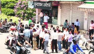 People gathered outside a jewellery shop which was looted in the Nehru Colony area of Dehradun on Wednesday. 