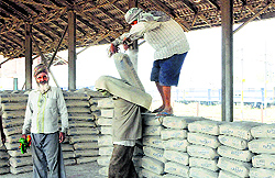 Labourers lift Pakistani cement in Amritsar on Wednesday