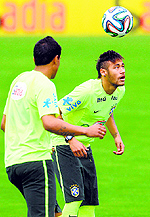 Striker Neymar (R) juggles with the ball next to teammate Paulinho during a training session of the Brazilian national football team at the squads Granja Comary training complex, in Teresopolis on Wednesday