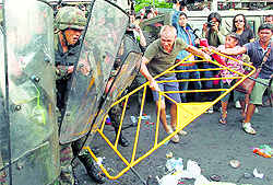 A soldier reacts while being hit with a metal barricade by a protester during a scuffle in Bangkok on Wednesday
