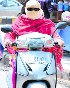 A women on a scooter during the hottest day of the season in Bathinda on Thursday