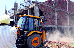 A building being demolished during an anti-encroachment drive in Zirakpur on Thursday