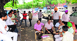 Contractors sit idle at a parking lot in Sector 17 after they decided to go on a one-day strike in protest against the Chandigarh Municipal Corporations move to impose service tax, on Thursday