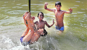 Children enjoy in a canal on a hot summer day in Jalandhar.