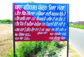 Heaping disgrace: One of the boards put up by the police authorities alongside a road leading to Daulewala village in Moga district