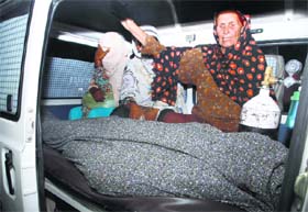 Women mourn over the body of their relative, Farzana Iqbal, in an ambulance outside of a morgue in Lahore