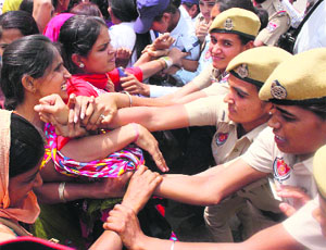 The police try to stop them from going out of the park in Bathinda on Friday.
