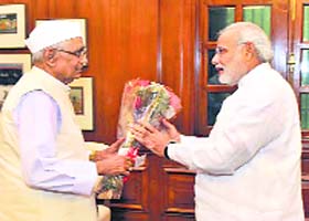 Greeting the new PM: Haryana Governor Jagannath Pahadia presents a bouquet to Prime Minister Narendra Modi in Delhi on Friday
