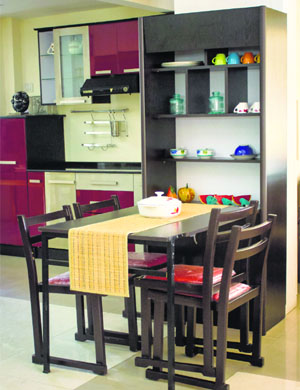 A dining table that can be folded and has storage at the bottom and stackable chairs