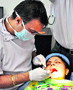 A doctor examines a patient at a dental check-up camp in Sector 21, Chandigarh, on Saturday