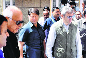 Chief Minister Omar Abdullah with his father Farooq Abdullah during a meeting of National Conference workers in Jammu on Saturday.