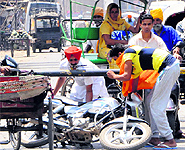 A view of a traffic jam at the level crossing at Ram Bagh in Amritsar; (right) even as the railway crossing is closed, commuters try to get through it
