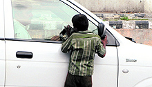 A child asks for alms at a traffic light point in Amritsar