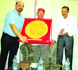 SDM Bhupinder Attari presents a silver shield to Assembly Speaker Brij Behari Lal Butail at Palampur.