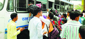 Candidates try to board a bus to reach their examination centres for taking the test for 300 posts of policemen in Sriganganagar on Sunday.