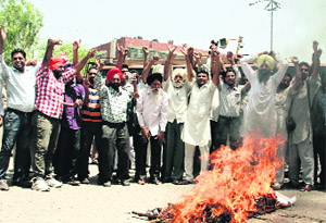 Members of various unions of the PRTC burn an effigy of the Punjab Government outside the bus stand in Bathinda on Monday.