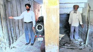 Kuldeep Singh (left), assistant engineer, Water Supply and Sanitation Department, shows water pipelines, parts of which pass underneath a structure which has come up on encroached land.