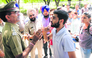 A security officer tries to pacify a student outside the VCs office at Panjab University on Monday.