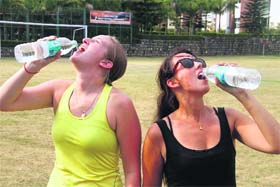 Beating the heat: Foreigners quench their thirst by drinking water as the mercury rose in Dehradun on Monday