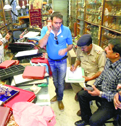 Police officials inspect the shop that was burgled at McLeodganj on Sunday.