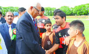 Governor NN Vohra interacts with players of the Air India football team at Bakshi Stadium in Srinagar on Monday.