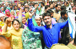 Relatives and family members of the infant raise slogans outside Lal Ded hospital in Srinagar on Monday.