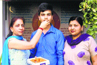 Rohit, who topped in the PSEB exam in the district, being congratulated by his mother and a teacher. 